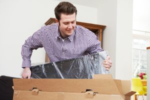 Washington man packing tv safely in a tv box is the best way to store a tv for moving and self storage moving boxes