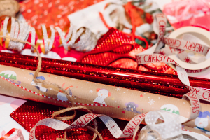 A pile of red, white, and brown paper wrapping paper, ribbons and wrapping supplies, ready to go into holiday decor storage.