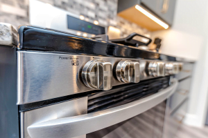 Close up photo of a stove and oven in a gray kitchen.