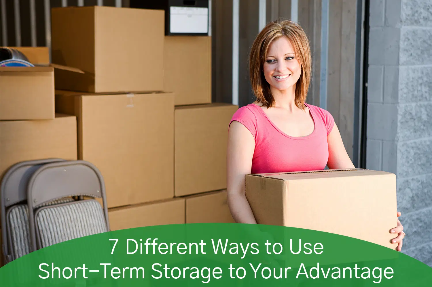 A white woman in a pink shirt filling up her short term storage unit with cardboard boxes.