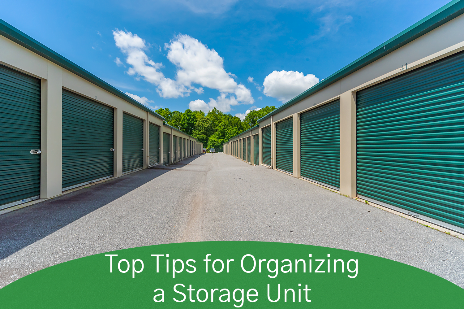 A storage unit facility row of storage units with green doors and tan walls.
