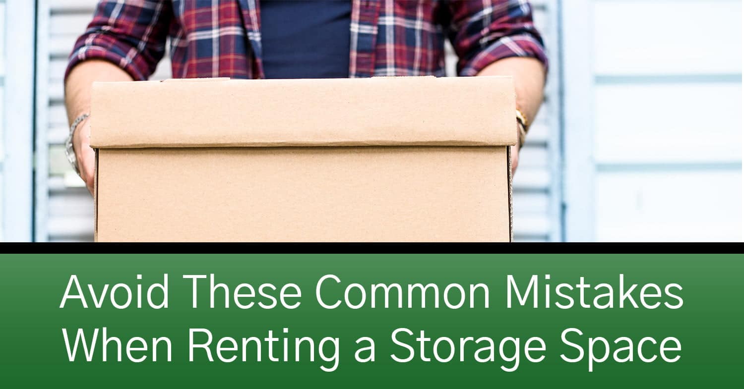 A man holding a cardboard box that's ready to go into a storage space.