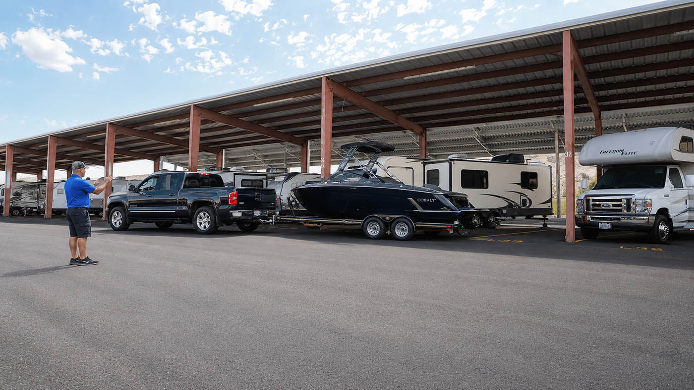 covered-boat-parking-with-wide-isles Truck backing a Cobalt boat trailer into a wide covered parking space at EZ Access Storage near Wenatchee, WA